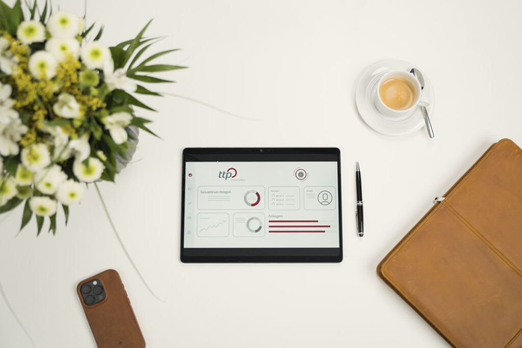 Flatlay: Tablet-Dashboard & Office-Setup Tablet mit ttp-Dashboard, Kaffee, Stift, Mappe und Blumen auf weißem Tisch
